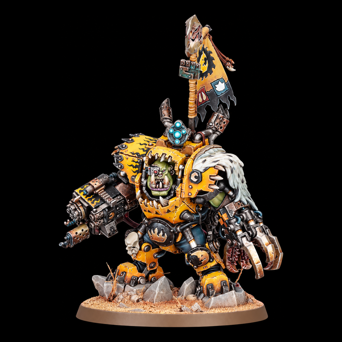 Miniatura Ork Nazdreg de Warhammer, con armadura amarilla, garra mecánica, arma de fuego y estandarte sobre peana rocosa.
