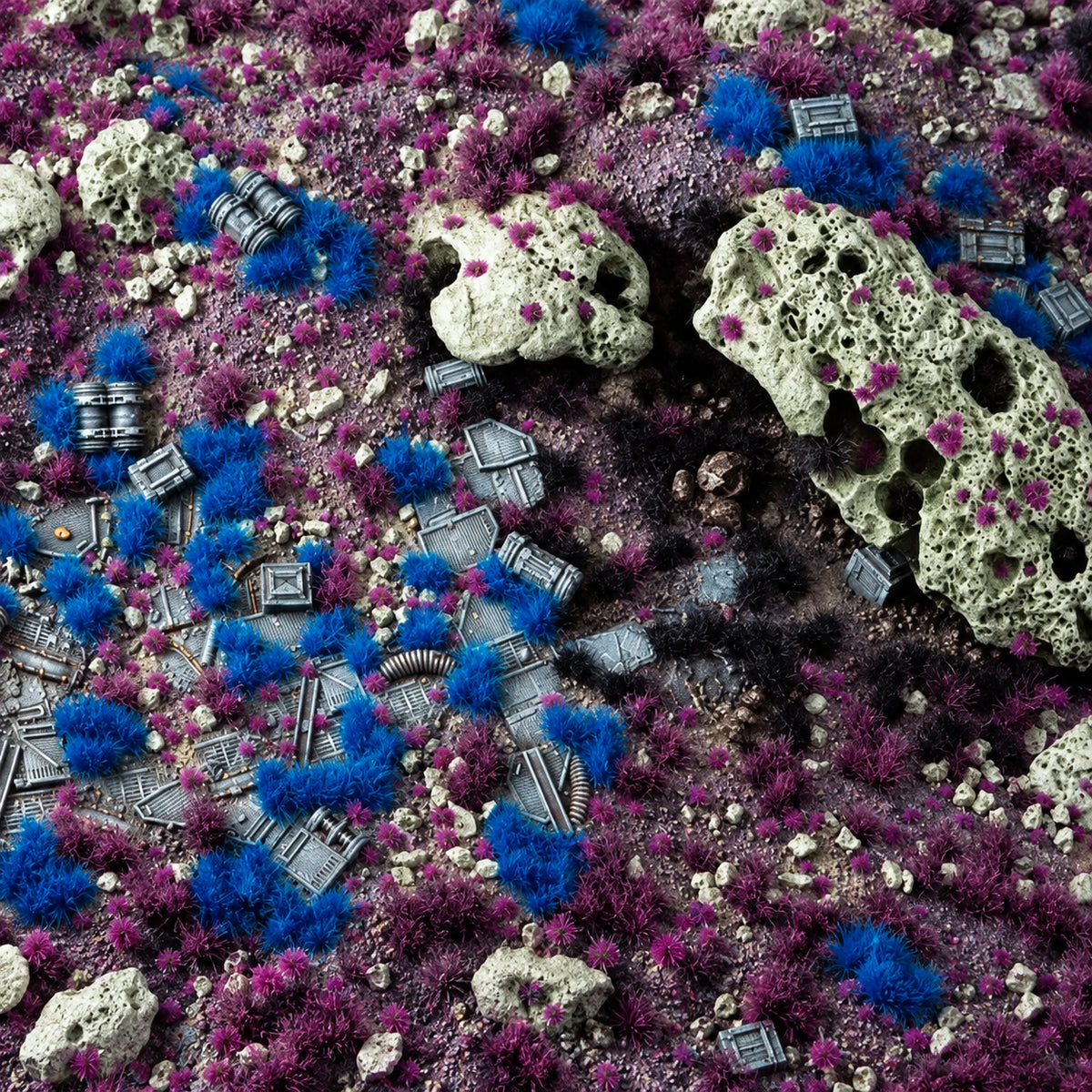 Diorama Alien de Gamer’s Grass con matas azules y moradas, rocas claras y restos de escenografía metálica.
