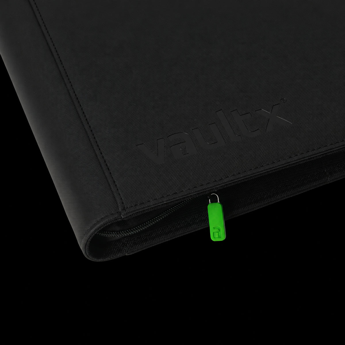 Detalle de la cubierta negra, el logotipo y la cremallera con tirador verde del álbum Vault X Exo-Tec XXL.