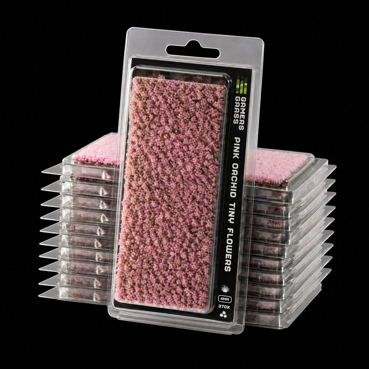Blíster Pink Orchid Tiny Flowers de Gamer’s Grass con pequeñas flores rosas y envases apilados detrás.