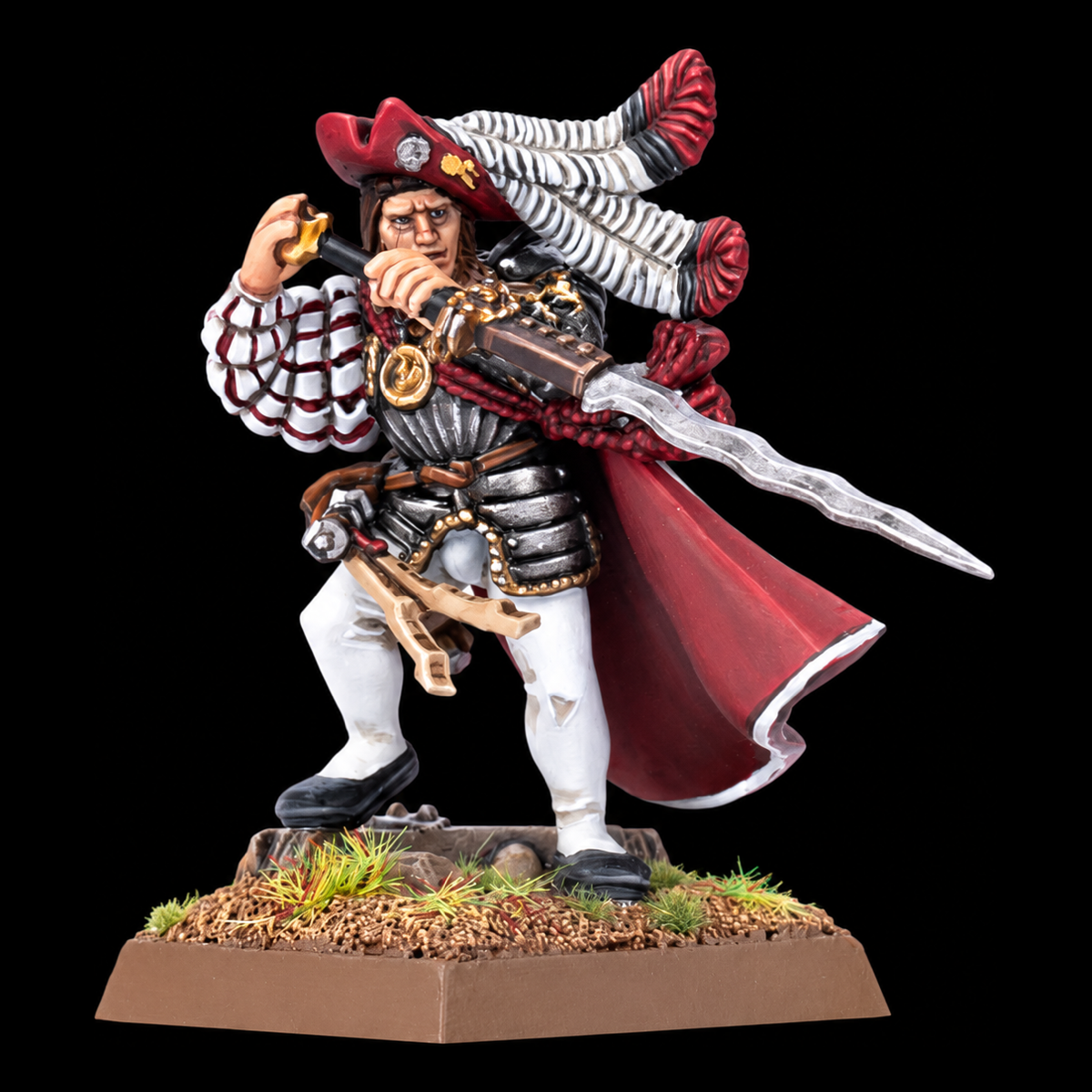 Miniatura de oficial del Imperio con sombrero de plumas, capa roja y espada sobre peana cuadrada.