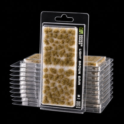 Blíster Light Brown 6 mm Wild de Gamer’s Grass con matas irregulares marrón claro y envases apilados.