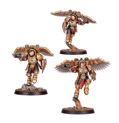 Tres miniaturas aladas de Adeptus Custodes Combat Patrol de Warhammer, con armaduras doradas, armas y escudos sobre peanas.