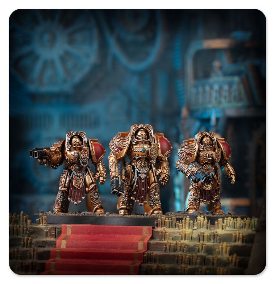 Tres miniaturas Custodes Aquilon Terminator de Warhammer doradas y rojas en un escenario con velas y escalinata roja.