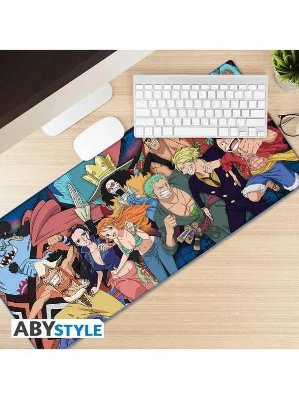 Tapete ABYstyle One Piece de la tripulación del Sombrero de Paja sobre un escritorio, bajo un teclado y un ratón blancos.